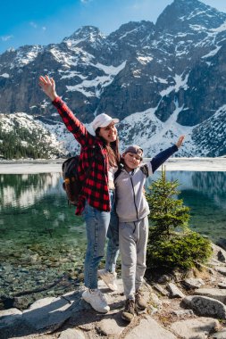 Mom with son are standing on the shore of a lake. Morskie Oko, Tatras mountains. Poland