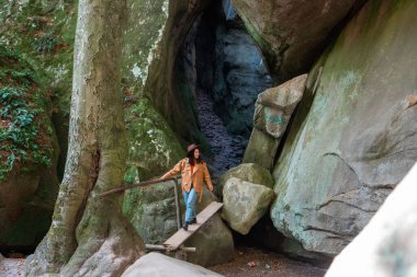 happy woman traveler walking by trail cave hiking
