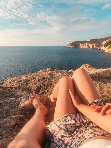 Pareja Sentada Acantilado Disfrutando Vista Del Atardecer Sobre Mar Sin —  Fotos de Stock