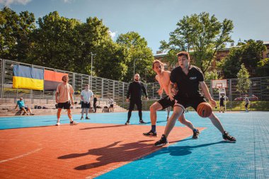 Lviv, Ukrayna - 28 Mayıs 2022: Erkekler açık havada güneşli bir yaz günü basketbol oynuyorlar