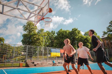 Lviv, Ukrayna - 28 Mayıs 2022: Erkekler açık havada güneşli bir yaz günü basketbol oynuyorlar