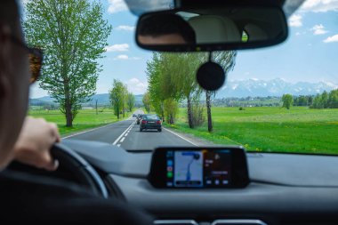 Adam araba kullanıyor. Dağlara giden yol.