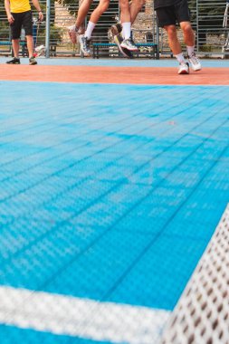 Erkekler açık havada basketbol oynuyorlar. Yüzlerini kopyalayamıyorlar.