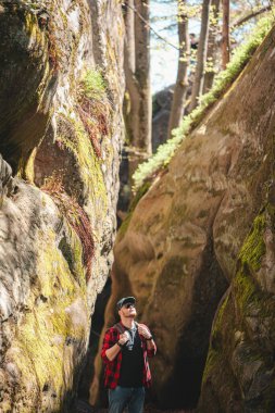 Sırt çantalı bir adam Ukrayna 'daki kanyon güvercini kayalarında yürüyor.