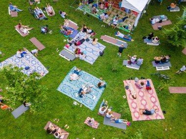 İnsanlar şehir parkında konsere giderken tepeden bakıyorlar.