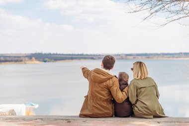 Sahilde gölü gören genç ve güzel bir aile. sonbahar sezonu