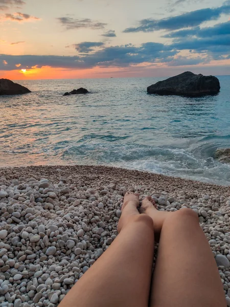 woman legs at the beach sunset above the sea Greece vacation