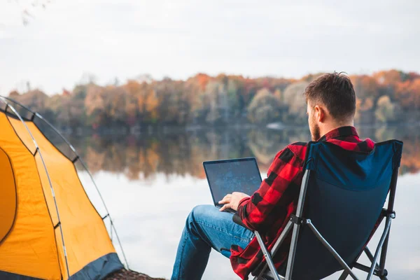 Mężczyzna Siedzi Krześle Pobliżu Jesiennego Jeziora Pracując Laptop Freelance Koncepcji — Zdjęcie stockowe