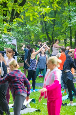 Lviv, Ukrayna - 2 Temmuz 2021: Şehir parkındaki birçok insan yoga yapıyor.