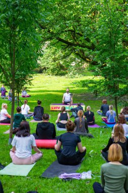 Lviv, Ukrayna - 2 Temmuz 2021: Şehir parkındaki birçok insan yoga yapıyor.