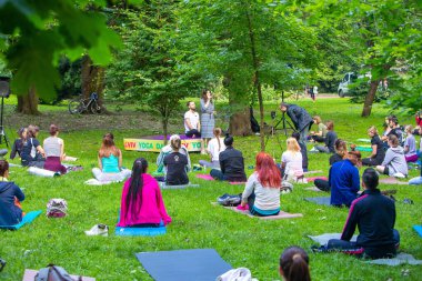 Lviv, Ukrayna - 2 Temmuz 2021: Şehir parkındaki birçok insan yoga yapıyor.