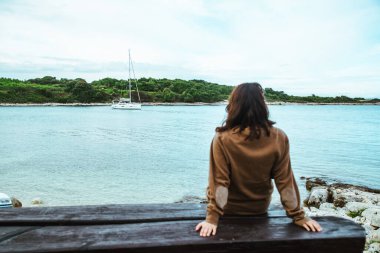 bankta oturan kadın koyda yatta bakıyor. kopyalama alanı