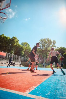 Lviv, Ukrayna - 28 Mayıs 2022: Erkekler açık havada güneşli bir yaz günü basketbol oynuyorlar