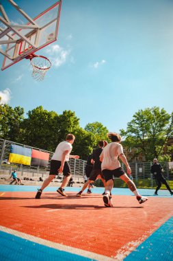 Lviv, Ukrayna - 28 Mayıs 2022: Erkekler açık havada güneşli bir yaz günü basketbol oynuyorlar