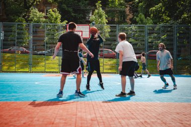 Lviv, Ukrayna - 28 Mayıs 2022: Erkekler açık havada güneşli bir yaz günü basketbol oynuyorlar
