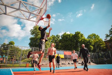 Lviv, Ukrayna - 28 Mayıs 2022: Erkekler açık havada güneşli bir yaz günü basketbol oynuyorlar