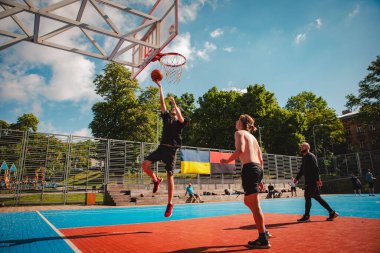 Lviv, Ukrayna - 28 Mayıs 2022: Erkekler açık havada güneşli bir yaz günü basketbol oynuyorlar