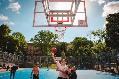 Lviv, Ukrayna - 28 Mayıs 2022: Erkekler açık havada güneşli bir yaz günü basketbol oynuyorlar