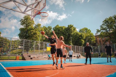 Lviv, Ukrayna - 28 Mayıs 2022: Erkekler açık havada güneşli bir yaz günü basketbol oynuyorlar