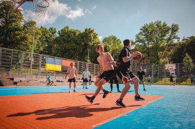 Lviv, Ukrayna - 28 Mayıs 2022: Erkekler açık havada güneşli bir yaz günü basketbol oynuyorlar