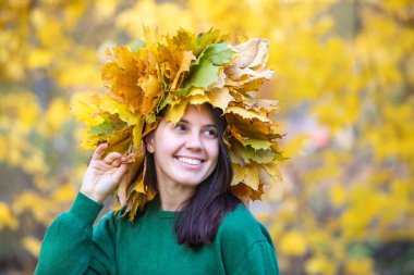 Güzel bir kadın portresi, başında akçaağaç yaprağı çelengi, sonbahar mevsimi.