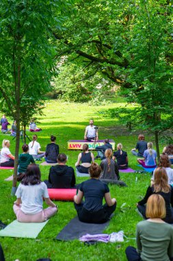 Lviv, Ukrayna - 2 Temmuz 2021: Şehir parkındaki birçok insan yoga yapıyor.