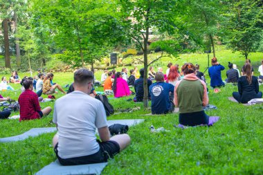 Lviv, Ukrayna - 2 Temmuz 2021: Şehir parkındaki birçok insan yoga yapıyor.