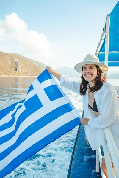 woman with greece flag at cruise boat lefkada island greece