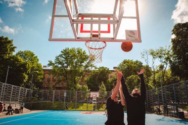 Lviv, Ukrayna - 28 Mayıs 2022: Erkekler açık havada güneşli bir yaz günü basketbol oynuyorlar