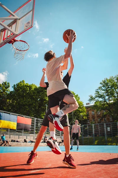 Lviv, Ukrayna - 28 Mayıs 2022: Erkekler açık havada güneşli bir yaz günü basketbol oynuyorlar