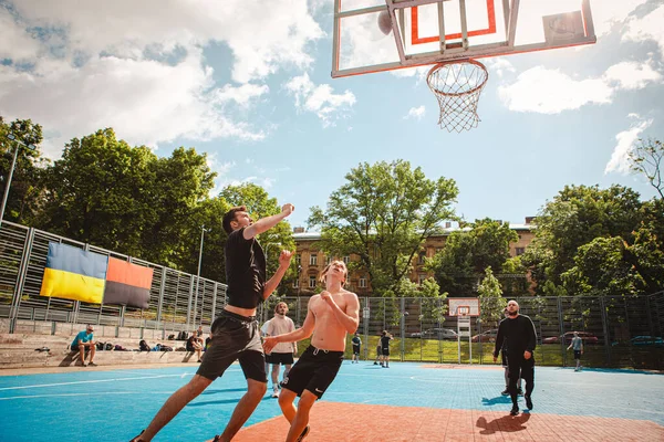 Lviv, Ukrayna - 28 Mayıs 2022: Erkekler açık havada güneşli bir yaz günü basketbol oynuyorlar