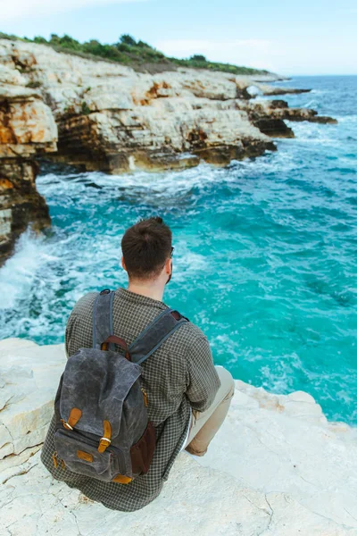 Homem Com Mochila Sentado Penhasco Desfrutando Vista Para Cidade Férias — Fotografia de Stock