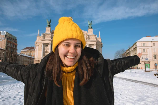 ライブシティのオペラビルの前で幸せな女性旅行者冬の雪の町 — ストック写真