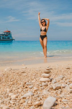 Yunan sahilindeki Lefkada Adası 'nda siyah mayo giymiş seksi bir kadın.