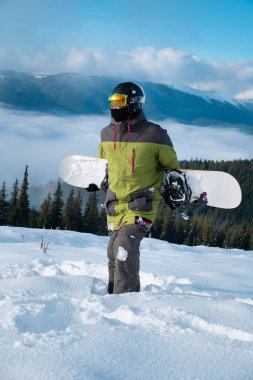 Snowboard sporcusu, arka plandaki Carpathian dağlarının portresi.