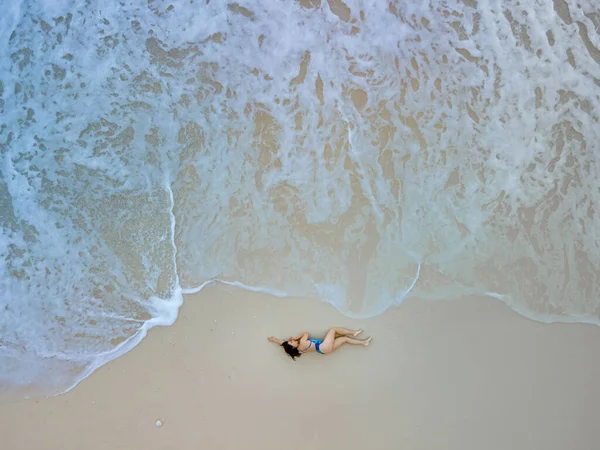 在海滩上穿着蓝色泳衣的女人俯瞰美丽的海浪 — 图库照片