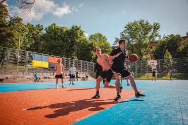 Lviv, Ukrayna - 28 Mayıs 2022: Erkekler açık havada güneşli bir yaz günü basketbol oynuyorlar