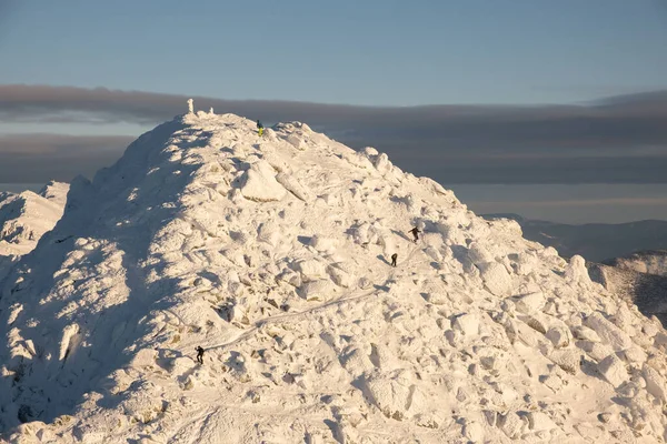 people climbing to the top of snowed mountains peak of Slovakia tatras