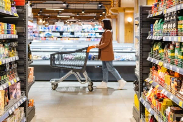 Kvinna Med Vagn Går Mellan Rader Hyllor Livsmedelsbutik — Stockfoto