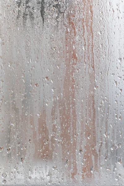 창문에 응집하고 떨어지고 내린다 공기중의 습도가 유리창 천연적 응축의 로열티 프리 스톡 사진