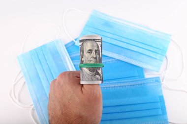 Yüz dolar, Coronavirus 'un tıbbi maskesinin arka planına karşı.