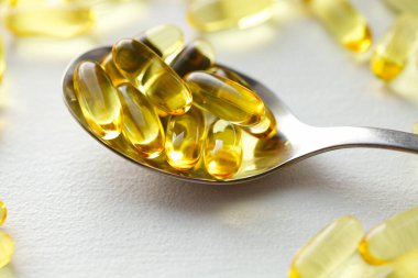 Beyaz arka planda biyolojik ve ekolojik CBD bitkisel yağ kapsülleri, şeffaf CBD cannabidiol kapsülleri grubu. Tıbbi esrar ürünleri