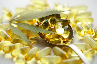 Tıbbi esrar ürünleri, yaprak, kapsüller beyaz arka planda CBD yağı. Biyolojik bitkisel bitkilerle birlikte jelatin softgeller. Organik beslenme takviyeleri kavramı