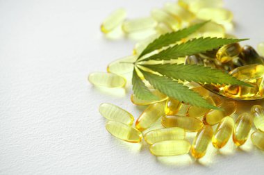 Beyaz arka planda biyolojik ve ekolojik CBD bitkisel yağ kapsülleri, şeffaf CBD cannabidiol kapsülleri grubu. Tıbbi esrar ürünleri