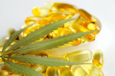 Tıbbi esrar ürünleri, yaprak, kapsüller beyaz arka planda CBD yağı. Biyolojik bitkisel bitkilerle birlikte jelatin softgeller. Organik beslenme takviyeleri kavramı