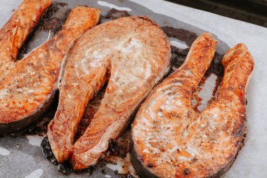 Fırında somon parçaları. Lezzetli, iştah açıcı somon balığı, kabın üzerinde yatıyor. Kızarmış balık bifteği.