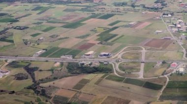 Çerçevenin sağına doğru kırsal alanda uçarak git. Yunanistan 'daki tarlaların ve otoyolun engellenmemiş pencere manzarası, yüksek irtifada seyreden uçaklarda görülüyor.