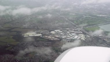Çerçevenin sağına bakarak yerleşim alanının üzerinde uçun. Yolcu penceresi yerleşim yerleri, Greater Manchester İngiltere bölgesinin üzerinde alçak irtifada seyreden bir uçakla otoyola sahip.