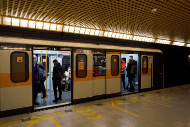 Milano, İtalya metro vagonunda Covid-19 maskesi takan insanlar. Coronavirus 'lu kalabalık Lombardy başkentinde yeraltı toplu taşımacılığı kullanılarak korunuyor..
