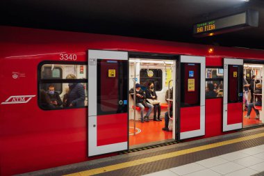 Milano, İtalya metro vagonunda Covid-19 maskesi takan insanlar. Coronavirus 'lu kalabalık Lombardy başkentinde yeraltı toplu taşımacılığı kullanılarak korunuyor..